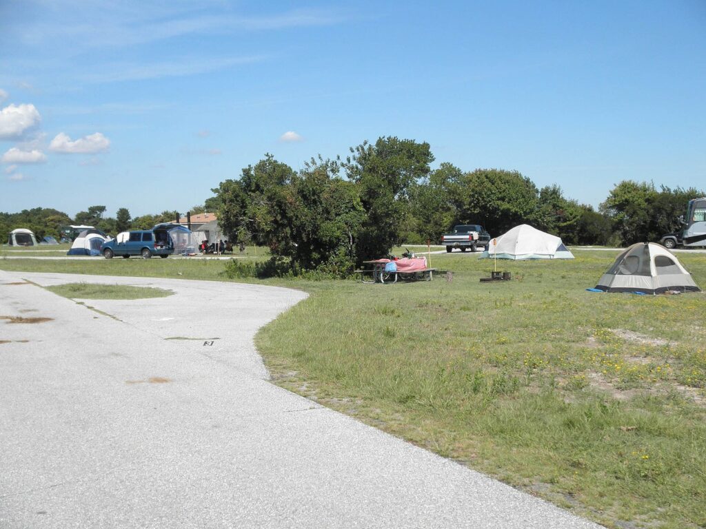 Tents, cars and picnic tables spread across a grassy loop at the Bayside campground on Assateague