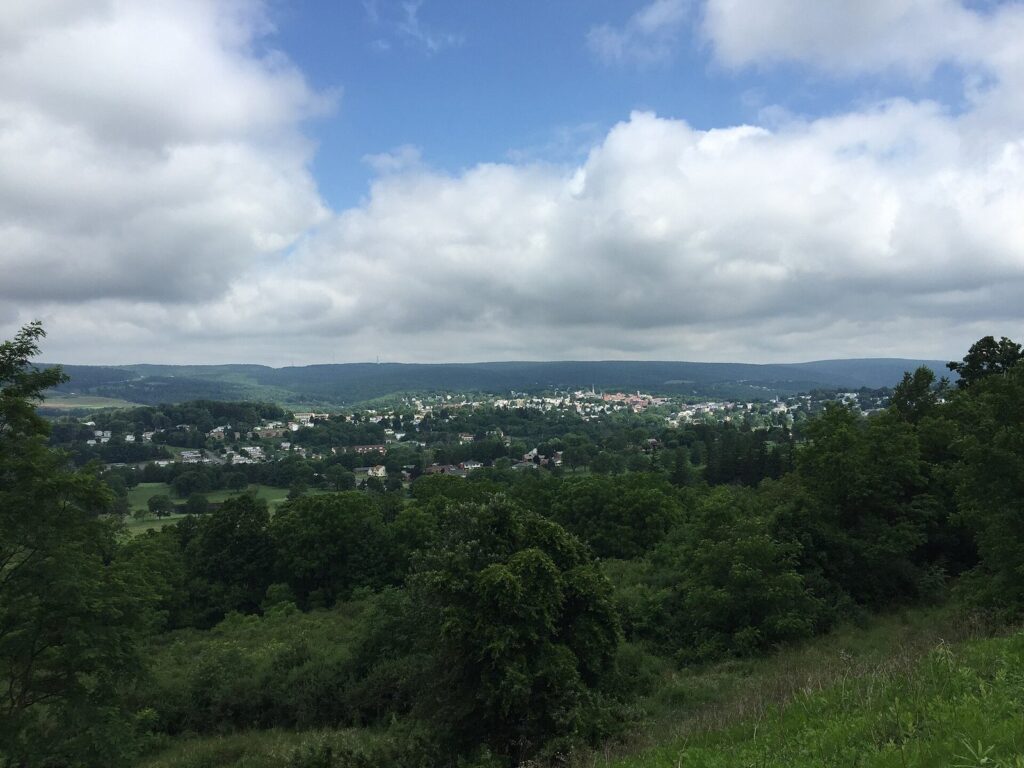 Green wooded hills and the rooftops of Frostburg spread across a valley under white clouds