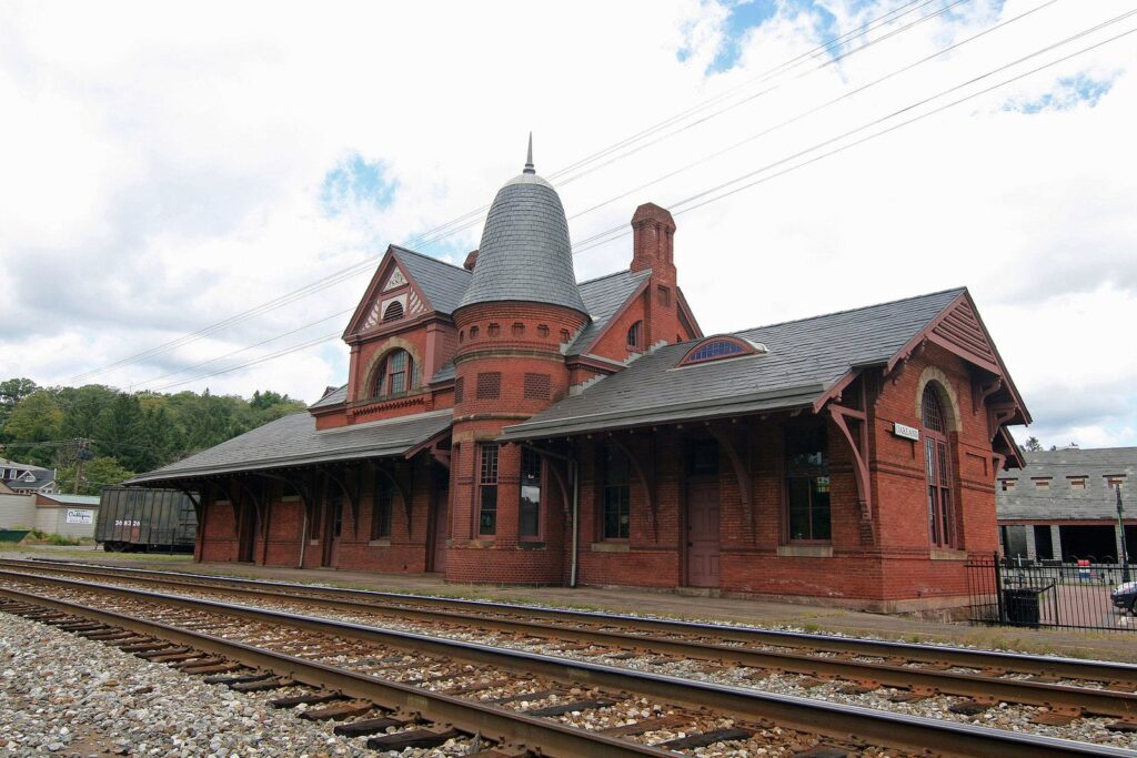 The red-brick Victorian railroad station in Oakland with a turret, beside the tracks