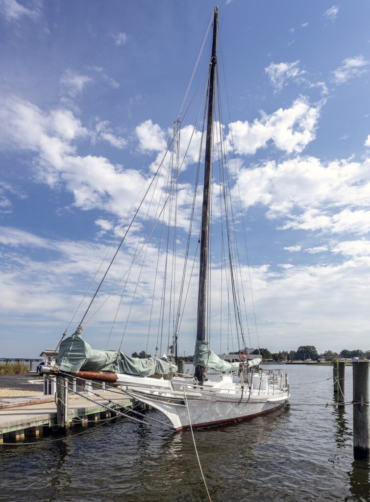 The skipjack Nathan of Dorchester tied up at a dock in Cambridge under a blue sky with scattered clouds