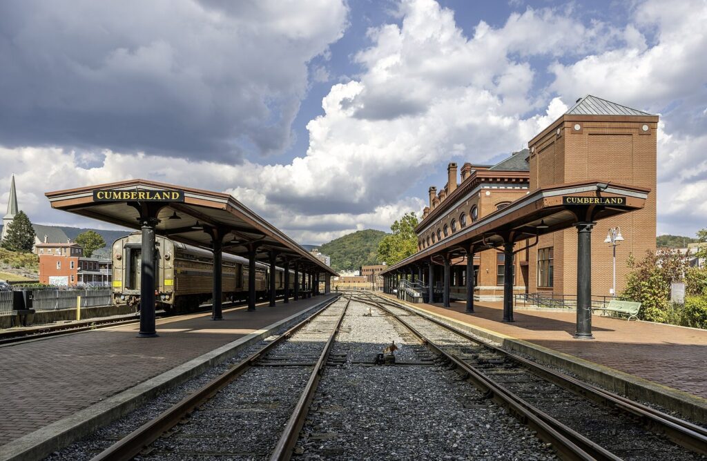 The brick railway station at Canal Place in Cumberland with its long covered platforms and a passenger car beside the tracks
